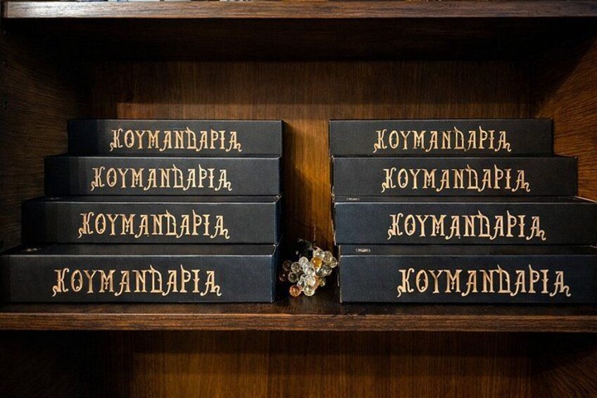 Een houten plank met zes zwarte boeken getiteld 'KOYMANDAPIA', gerangschikt in twee rijen. 4