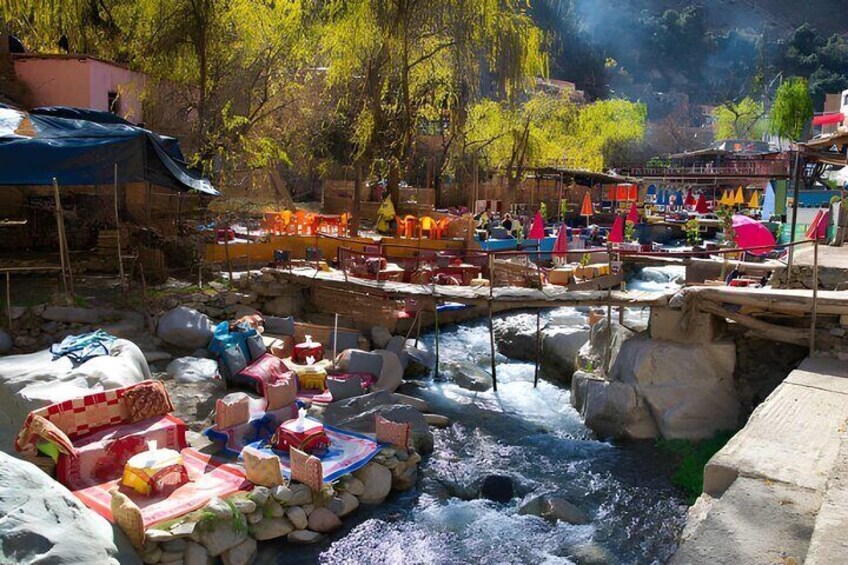 A river with boats, rocks, and a bridge. 1