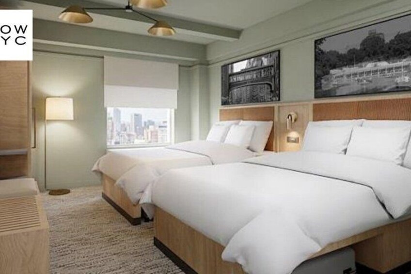 Ett hotellrum med två sängar, utsikt över staden, en inramad tavla på väggen och en lampa. 5