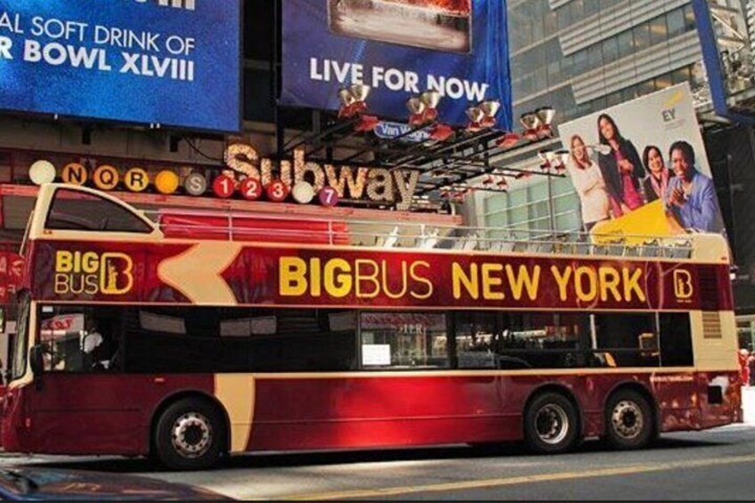 En röd och gul Big Bus-sightseeingbuss i New York med reklam för tunnelbanan på sidan. 4