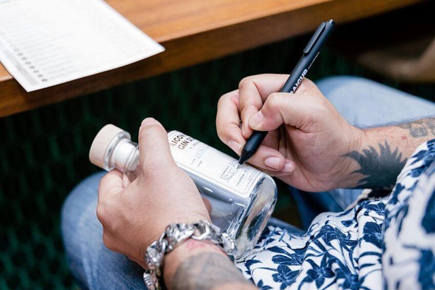 A person holding a pen and a bottle, possibly writing or labeling. 3