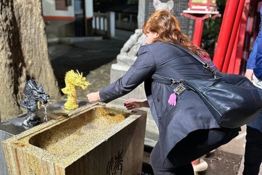 Una persona interagisce con un elemento acquatico che include una statua di un drago. 5