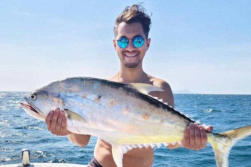 Une personne tenant un poisson sur un bateau. 3