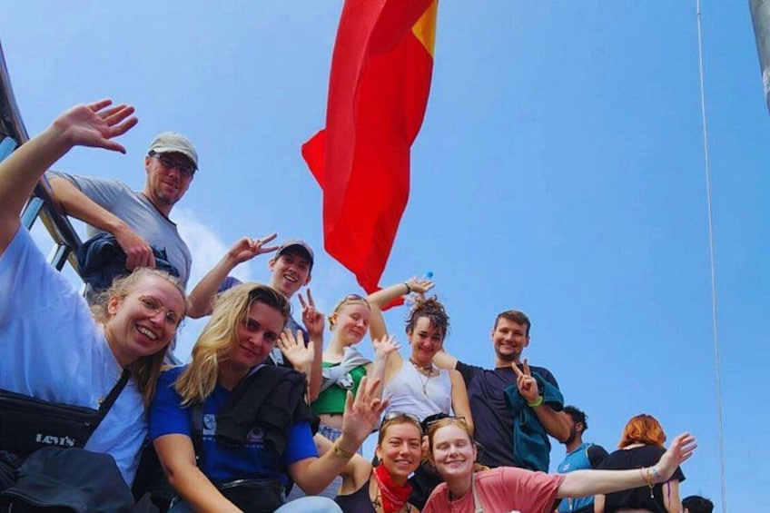 Eine Gruppe von Menschen auf einem Boot winkt mit einer roten Flagge. 5