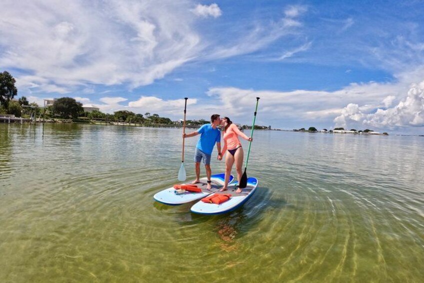 Two people paddleboarding on a calm lake with clear skies. 4