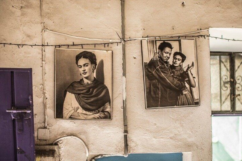 Un muro con due fotografie incorniciate e una porta viola. 5