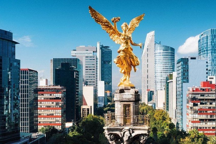 Una statua dorata di un angelo alato, con sullo sfondo moderni grattacieli e un cielo azzurro limpido. 3
