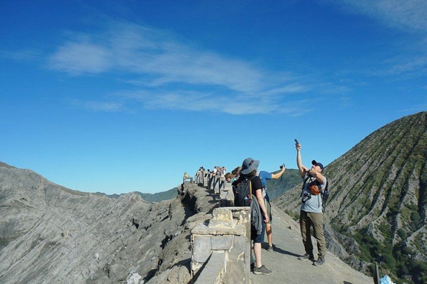A group of hikers on a rocky mountain trail with clear skies. 4