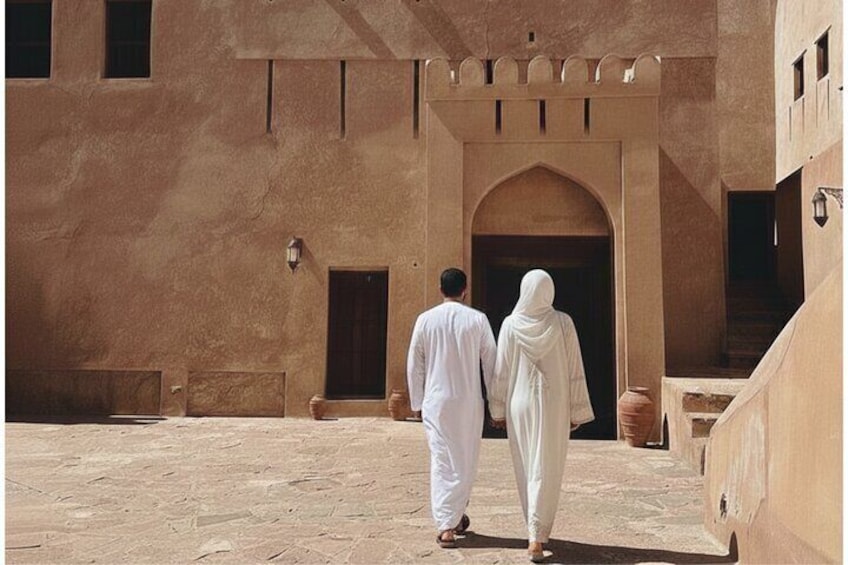 Two people walking in a courtyard with a building in the background. 1