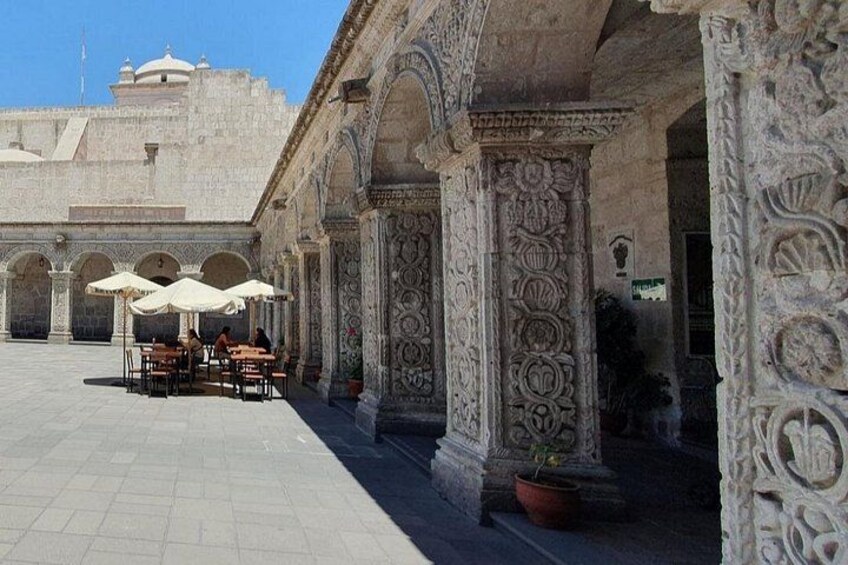 Un café en plein air, doté de colonnes richement décorées et d’un sol carrelé. 4