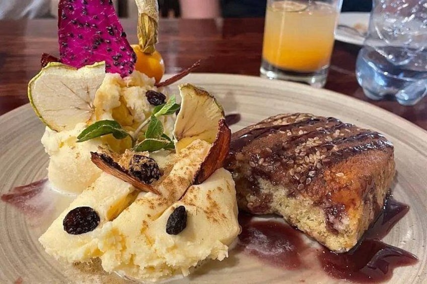 Une assiette de dessert avec une boule de glace, une part de gâteau et une boisson en arrière-plan. 2