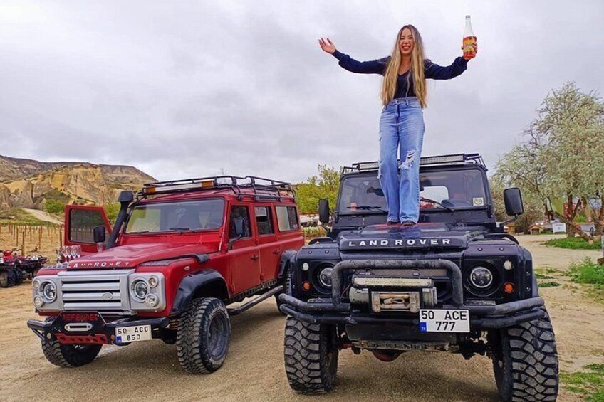 Un Land Rover rojo y un Land Rover negro con una persona de pie sobre el vehículo negro. 5