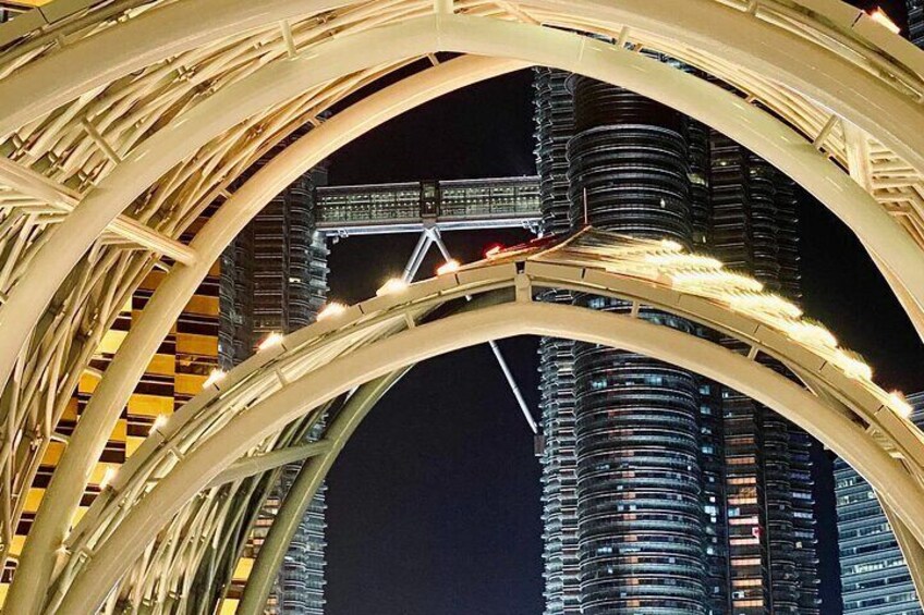 A nighttime view of a cityscape with illuminated arches and a bridge. 5