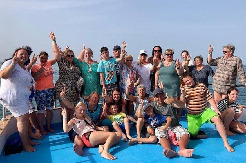 A group of people on a boat with a blue tarp on the deck. 3