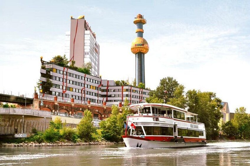 A river with a boat, a tall tower, and a building with a unique design. 1