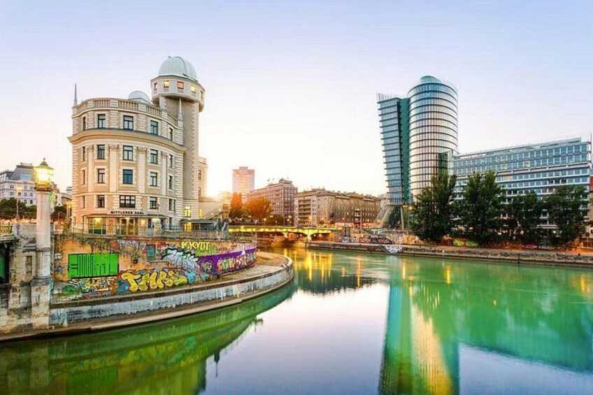 A river with buildings, including a curved structure and a tall cylindrical building. 3
