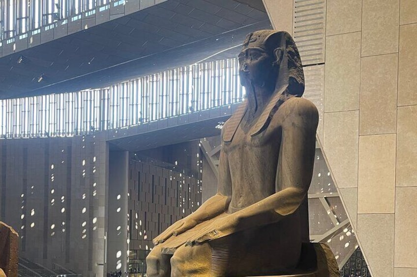 A large ancient Egyptian statue in a modern building. 3