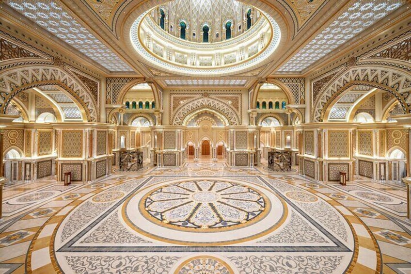 Un interior ornamentado con un gran mosaico circular, techos abovedados y diseños intrincados. 1