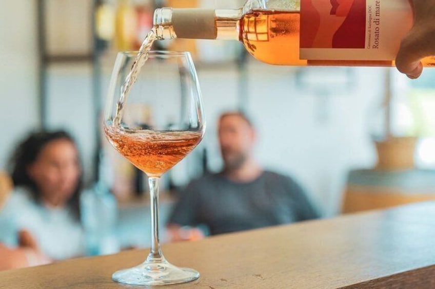 Ein Weinglas wird mit Roséwein gefüllt. 4