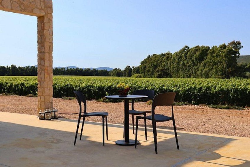 Une terrasse extérieure agrémentée d’une arche en pierre, de deux tables et de quatre chaises. 3