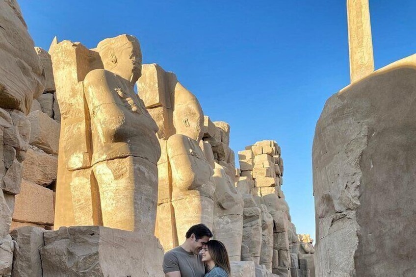 Una pareja parada frente a grandes estatuas de piedra. 4