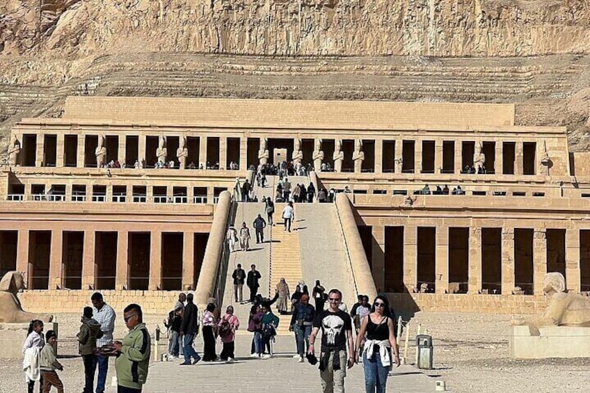 Un extenso y antiguo complejo de templos egipcios con una gran escalera que conduce a la entrada. 1
