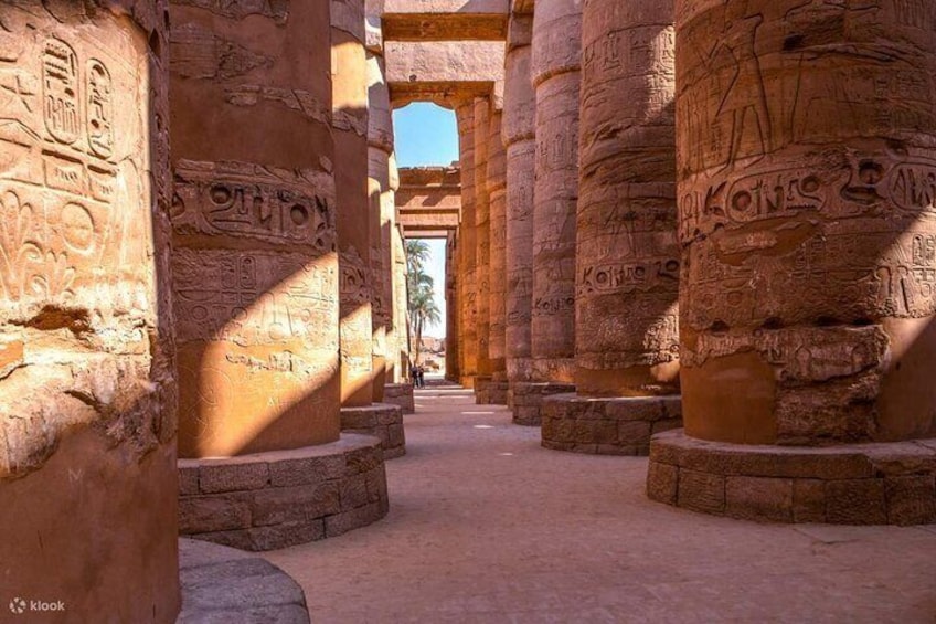 Columnas egipcias antiguas con jeroglíficos, cielo despejado y un sendero. 5