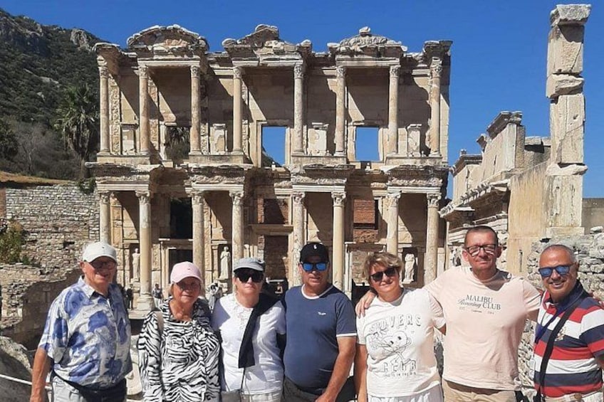 A group of people standing in front of ancient ruins with columns and arches. 3