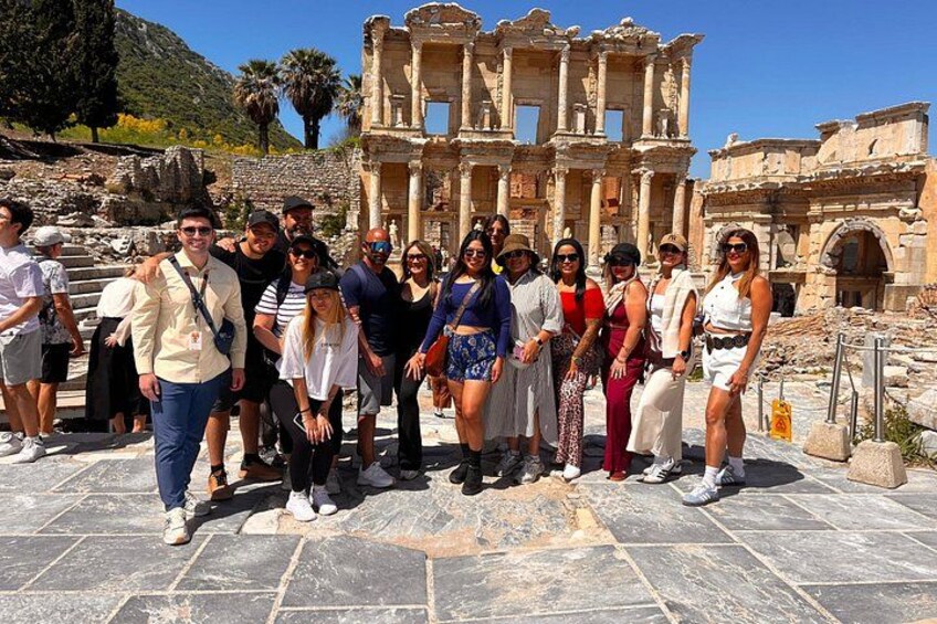 A group of people posing in front of ancient ruins with columns and arches. 4