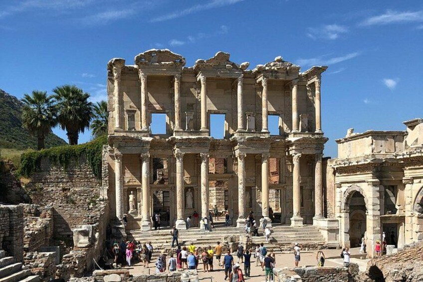 Ancient ruins with columns and steps, surrounded by tourists. 5