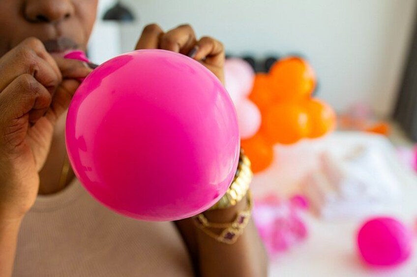 Eine Person hält einen rosafarbenen Ballon. 4