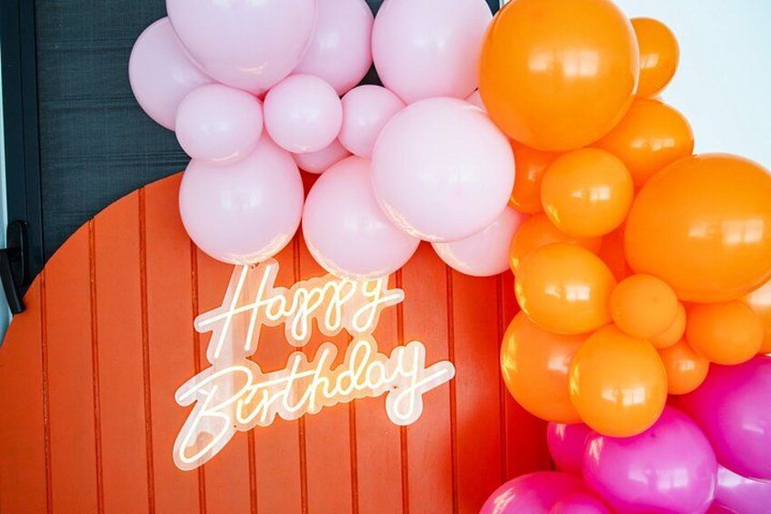 Geburtstagsfeier mit Luftballons und einem Neon-Schild mit der Aufschrift 'Happy Birthday'. 5
