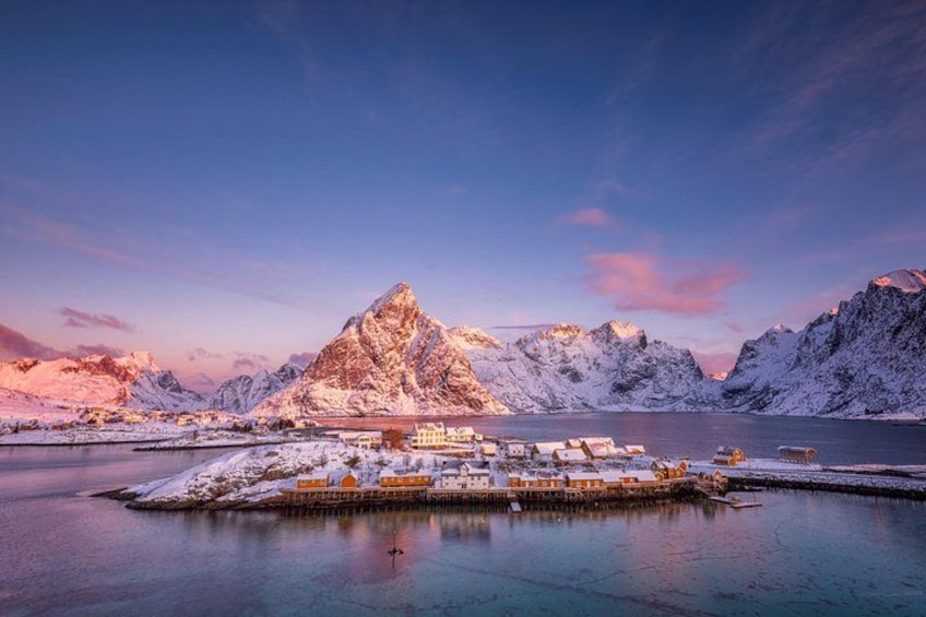Ein schneebedeckter Berg, ein See und eine kleine Siedlung mit Häusern. 2