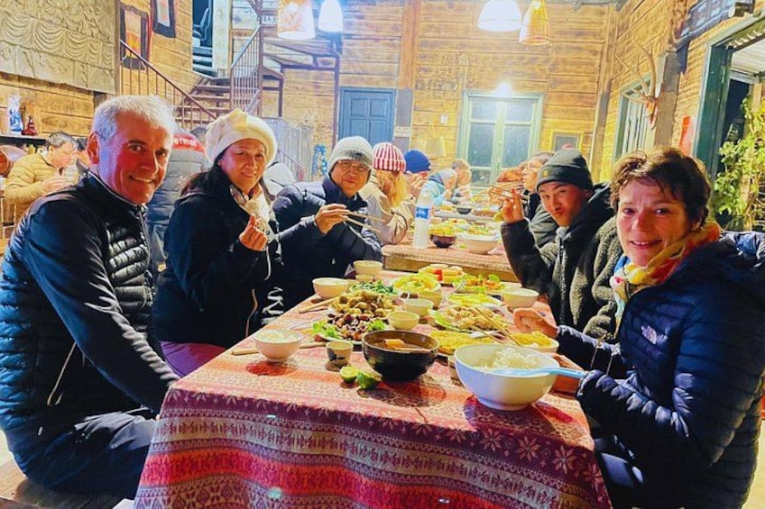 Eine Gruppe von Personen genießt ein Essen an einem Tisch mit verschiedenen Gerichten. 3