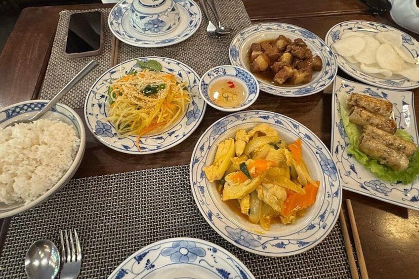 A table with various dishes including rice, noodles, and meat. 3