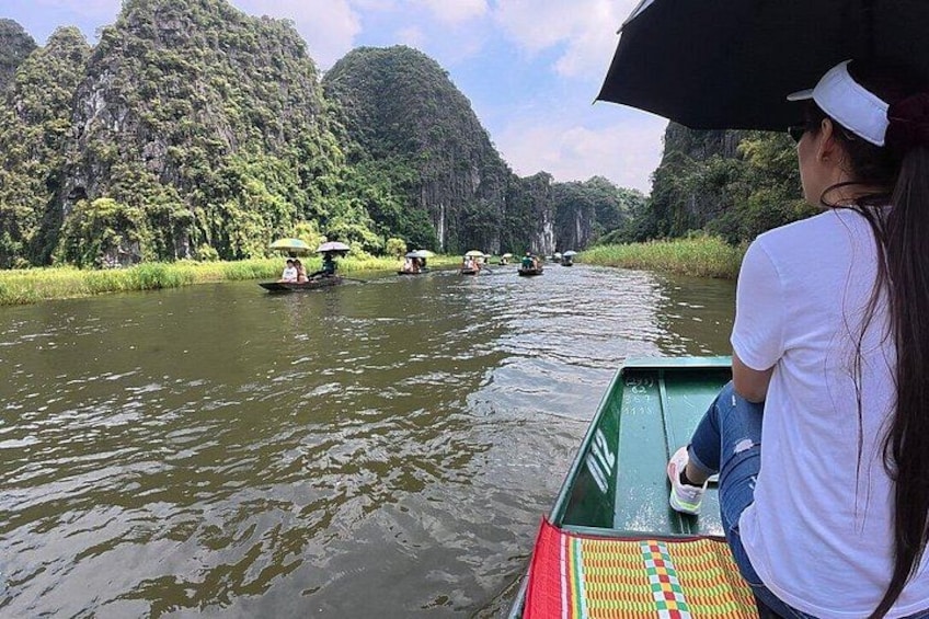 A river with boats, lush greenery, and a hilly landscape. 5