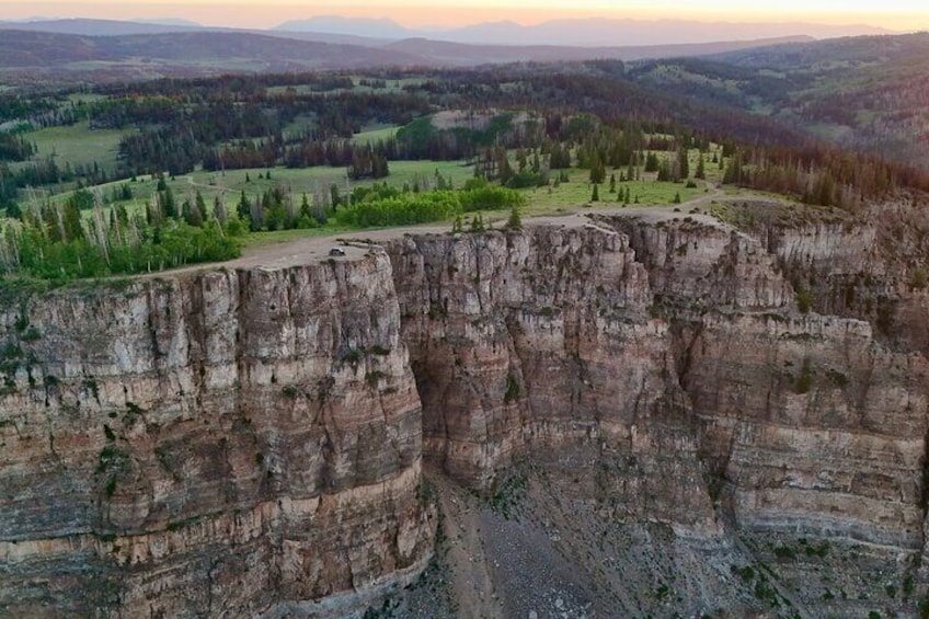 Eine hohe, steile Klippe, umgeben von grünen Feldern und Bäumen. 1