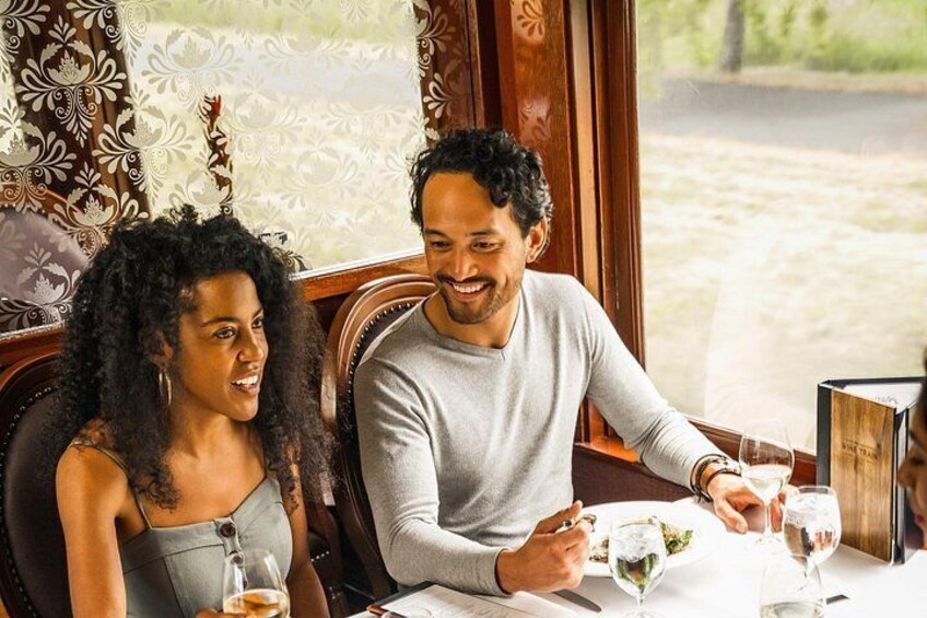 A couple dining at a restaurant with a view of a garden. 2