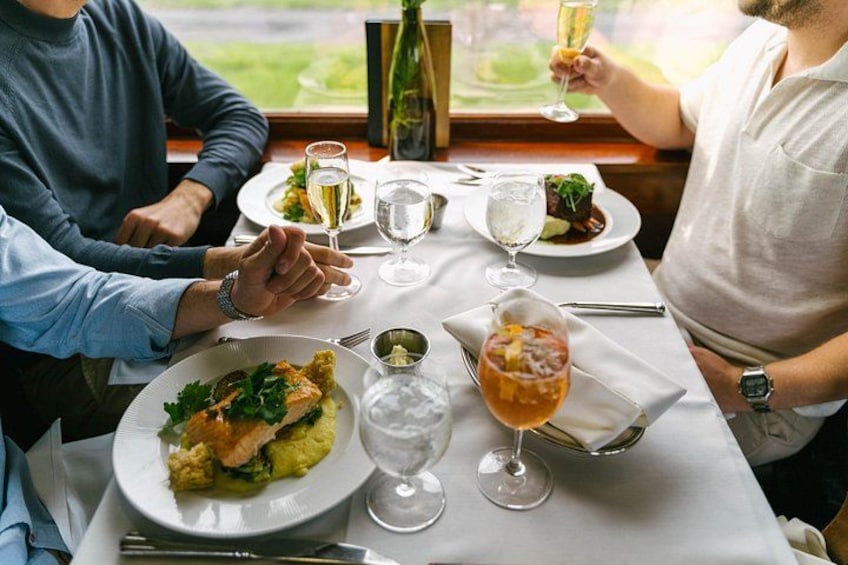 Et spisebord med tallerkener med mad, vinglas og en champagneflaske. 3