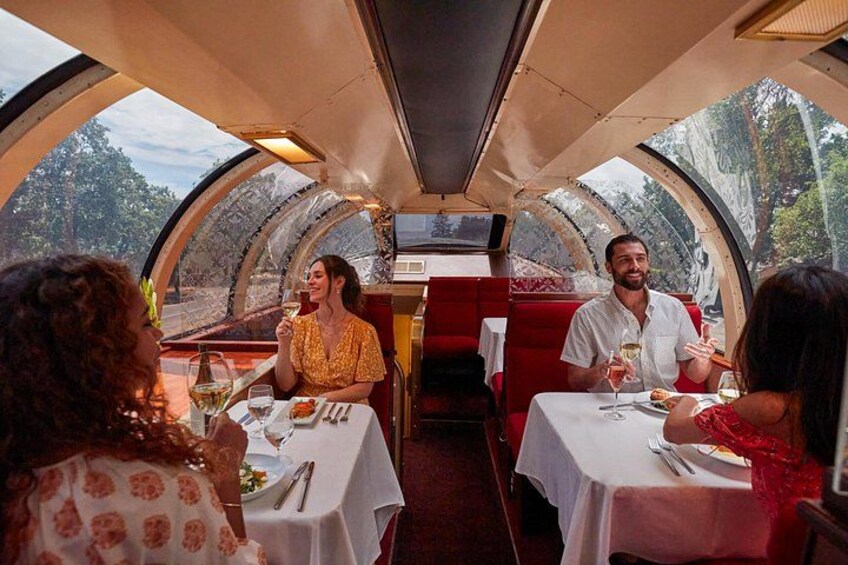 A dining car with tables and red upholstered seats. 4