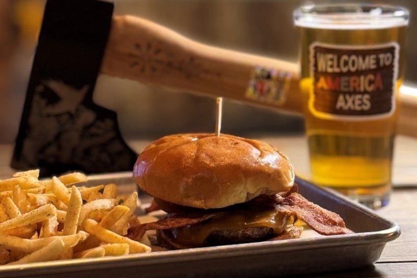 Una hamburguesa con papas fritas y una jarra de cerveza en un plato. 1
