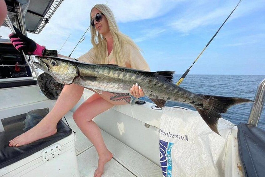 A person holding a large fish on a boat. 1