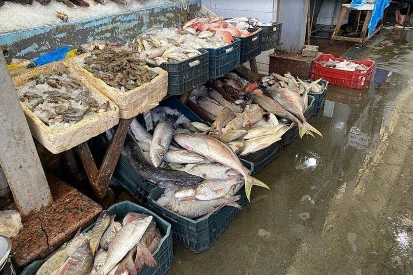 Et fiskemarked med forskellige fisketyper udstillet i kasser og på is. 2
