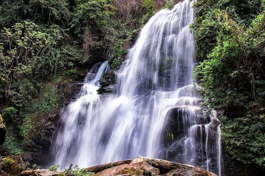 A multi-tiered waterfall surrounded by dense forest. 4