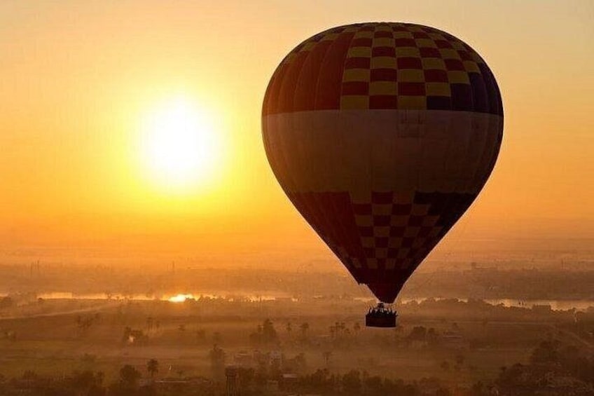 A hot air balloon over a landscape during sunset. 5