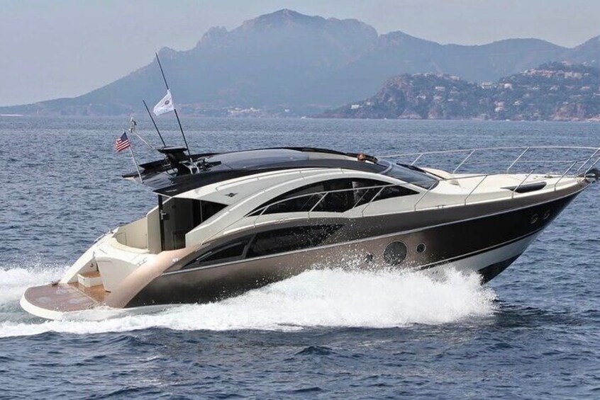 Un yacht élégant et moderne navigue sur une mer calme, avec des montagnes en arrière-plan. 3