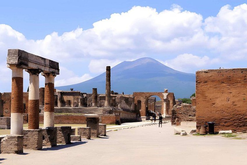 Ancient ruins with columns and arches, a clear sky, and a mountain in the background. 5