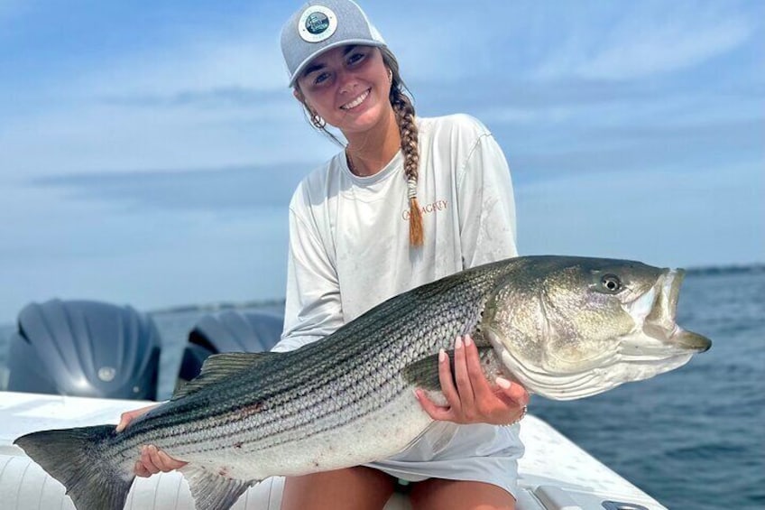 A person holding a large fish on a boat. 3