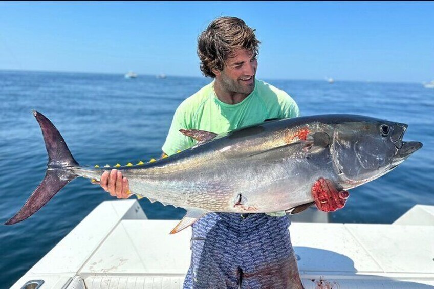 Una persona tiene in mano un pesce di grandi dimensioni su una barca. 2