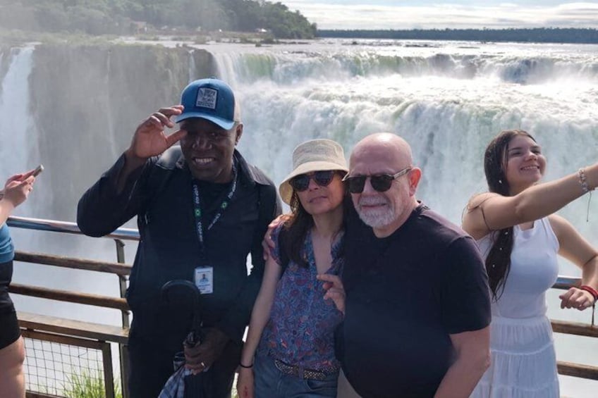 A group of people standing by a waterfall. 1